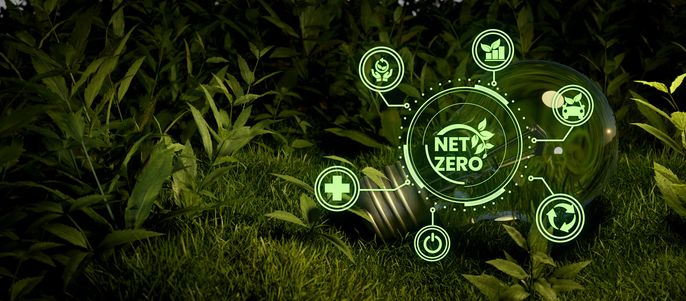 Eine Glühbirne, umgeben von grünen holografischen Symbolen, die verschiedene Umweltthemen darstellen, mit dem auffälligen "NET ZERO"-Label in der Mitte.