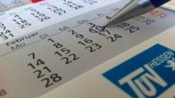 Ein Kalender mit einem blau eingekreisten Datum und dem Logo des TÜV Hessen unten rechts.