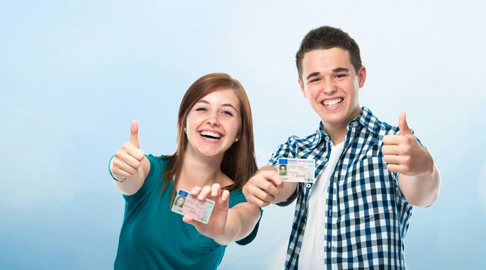 Zwei Personen, ein Mann und eine Frau, zeigen beide mit ihren Händen den Daumen nach oben. Sie halten ihre Ausweise hoch.